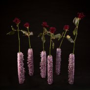 Black Baccara roses in candle wax vases