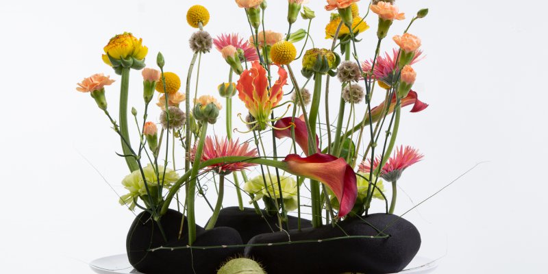 Summery flower arrangement in black floral foam